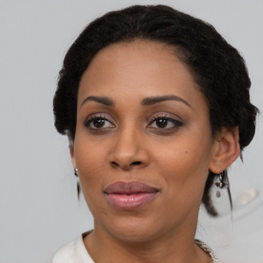 Joyful black adult female with short  black hair and brown eyes