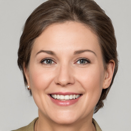 Joyful white young-adult female with medium  brown hair and grey eyes