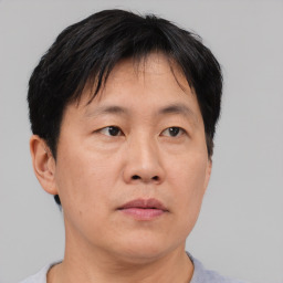 Neutral asian adult male with short  brown hair and brown eyes