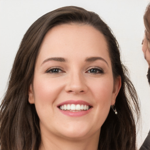 Joyful white young-adult female with long  brown hair and brown eyes