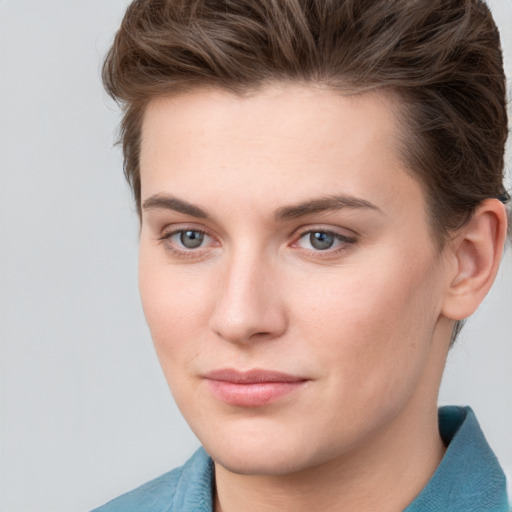 Joyful white young-adult female with short  brown hair and grey eyes