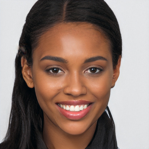 Joyful black young-adult female with long  brown hair and brown eyes