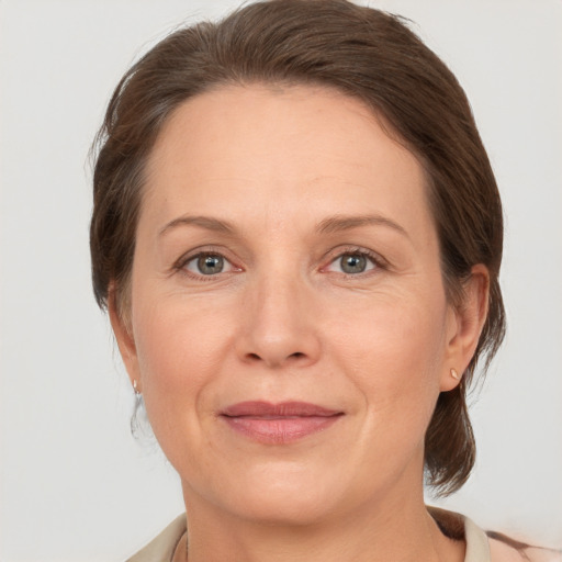 Joyful white adult female with medium  brown hair and grey eyes