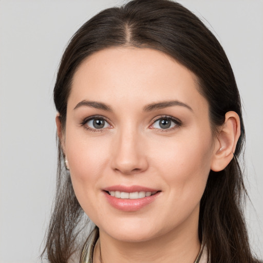 Joyful white young-adult female with long  brown hair and brown eyes