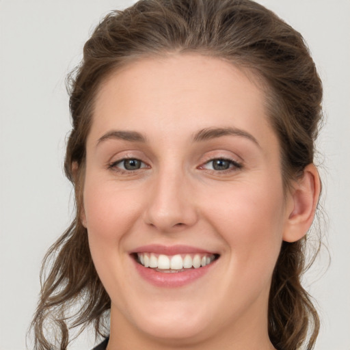 Joyful white young-adult female with long  brown hair and green eyes