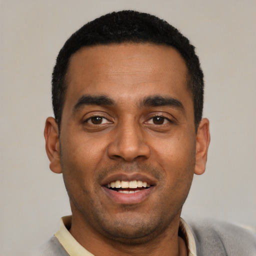 Joyful black young-adult male with short  black hair and brown eyes