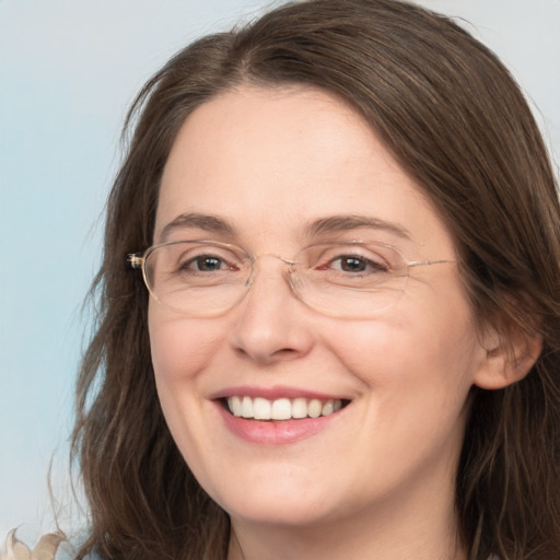 Joyful white adult female with long  brown hair and grey eyes