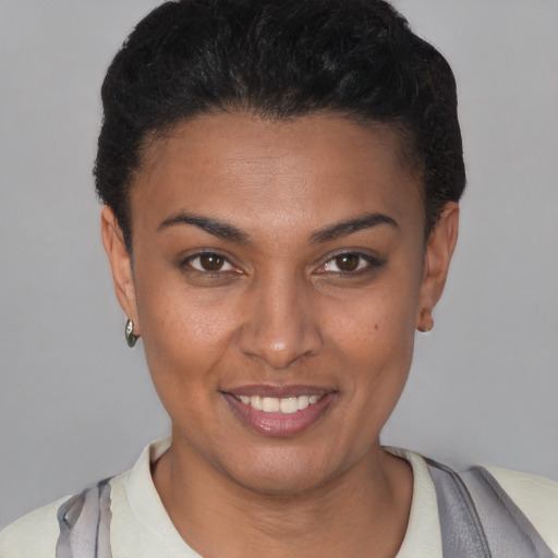 Joyful latino young-adult female with short  black hair and brown eyes