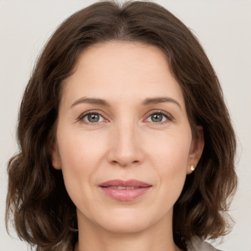 Joyful white young-adult female with medium  brown hair and green eyes