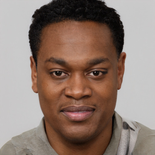 Joyful black young-adult male with short  brown hair and brown eyes