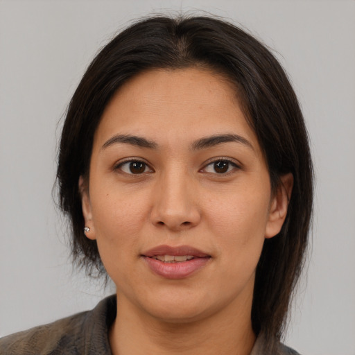 Joyful latino young-adult female with medium  brown hair and brown eyes