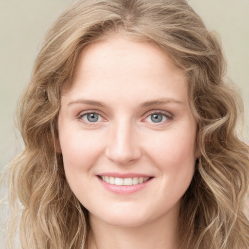 Joyful white young-adult female with long  brown hair and blue eyes