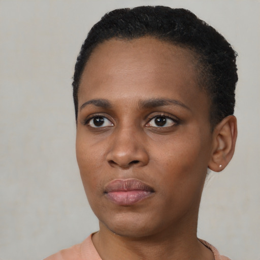 Joyful black young-adult female with short  black hair and brown eyes