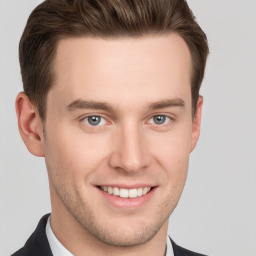 Joyful white young-adult male with short  brown hair and grey eyes