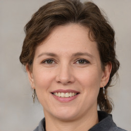 Joyful white adult female with medium  brown hair and grey eyes