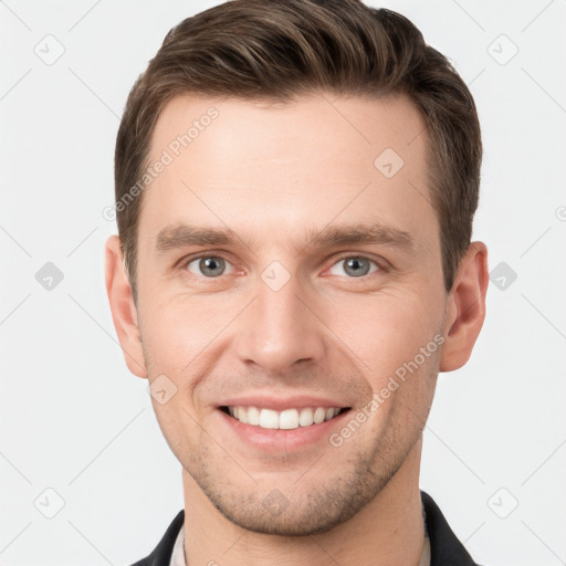 Joyful white young-adult male with short  brown hair and grey eyes