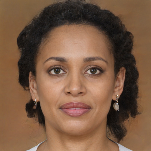 Joyful black adult female with medium  brown hair and brown eyes