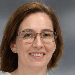 Joyful white adult female with medium  brown hair and blue eyes