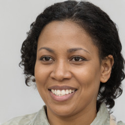 Joyful black adult female with medium  brown hair and brown eyes