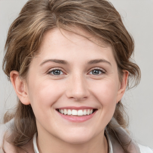 Joyful white young-adult female with medium  brown hair and grey eyes