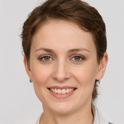 Joyful white young-adult female with medium  brown hair and grey eyes