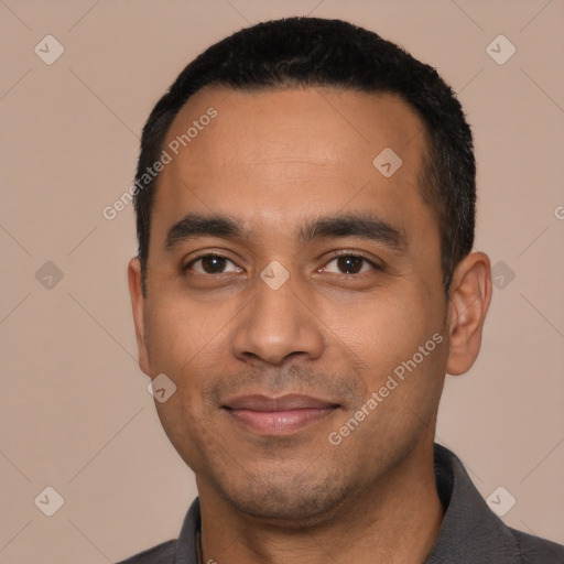 Joyful latino young-adult male with short  black hair and brown eyes