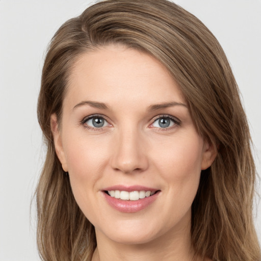 Joyful white young-adult female with long  brown hair and grey eyes