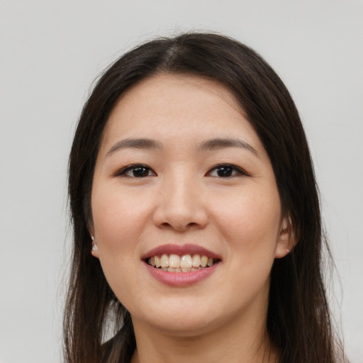 Joyful asian young-adult female with long  brown hair and brown eyes