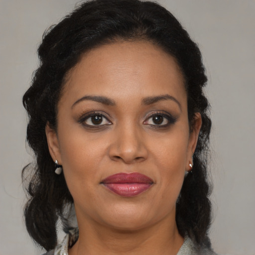 Joyful black adult female with medium  brown hair and brown eyes