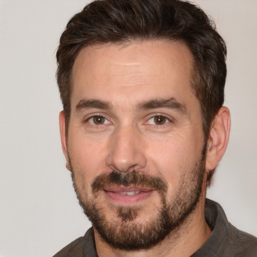 Joyful white adult male with short  brown hair and brown eyes