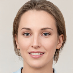 Joyful white young-adult female with medium  brown hair and grey eyes