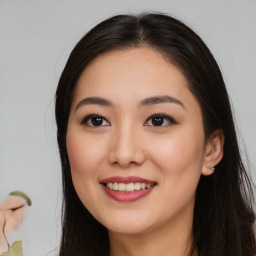 Joyful asian young-adult female with long  brown hair and brown eyes