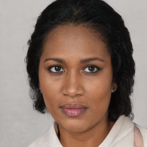 Joyful black young-adult female with medium  black hair and brown eyes