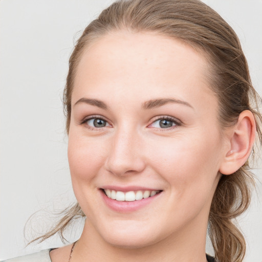 Joyful white young-adult female with long  brown hair and blue eyes