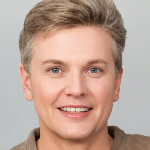 Joyful white adult male with short  brown hair and grey eyes