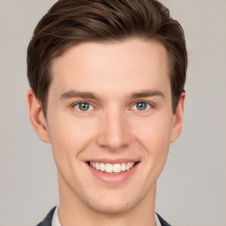 Joyful white young-adult male with short  brown hair and grey eyes