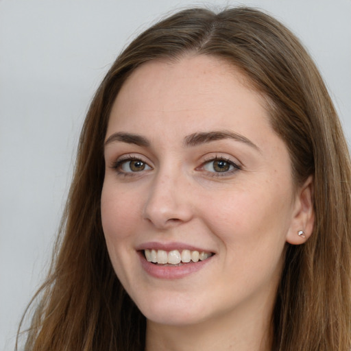 Joyful white young-adult female with long  brown hair and blue eyes