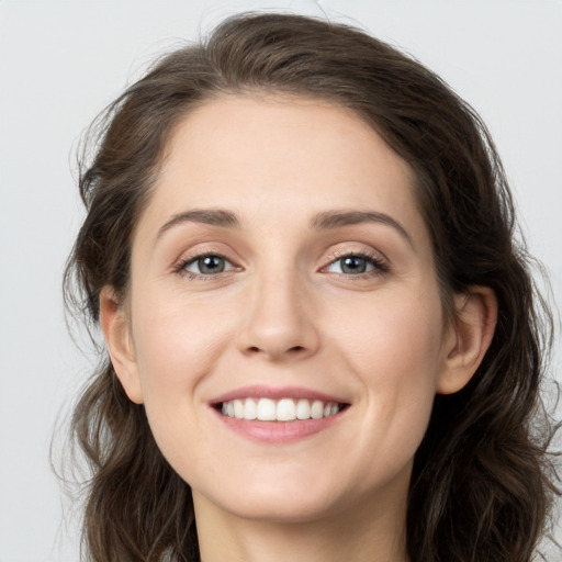 Joyful white young-adult female with long  brown hair and grey eyes