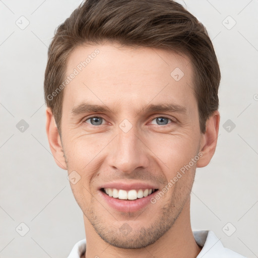 Joyful white young-adult male with short  brown hair and grey eyes