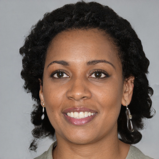 Joyful black young-adult female with medium  black hair and brown eyes
