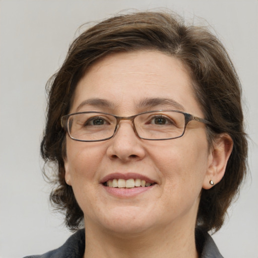 Joyful white adult female with medium  brown hair and grey eyes