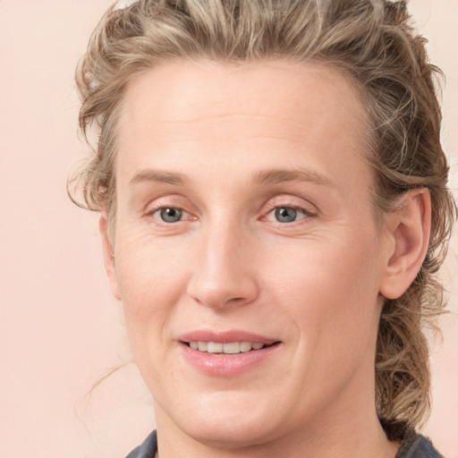 Joyful white young-adult female with medium  brown hair and blue eyes