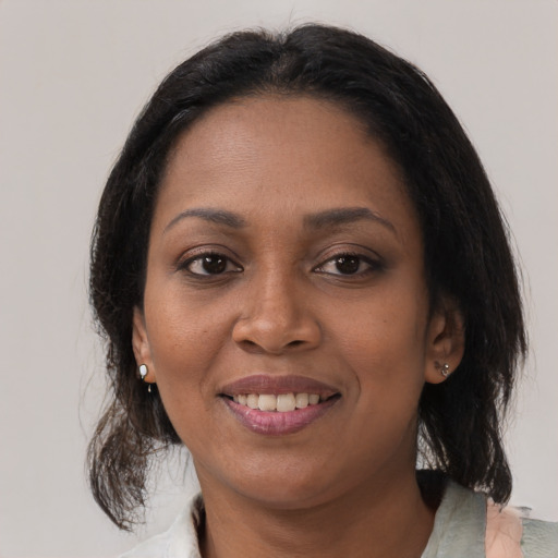 Joyful black young-adult female with medium  brown hair and brown eyes