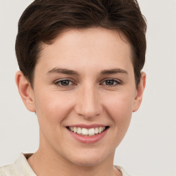 Joyful white young-adult female with short  brown hair and grey eyes