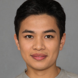 Joyful latino young-adult male with short  brown hair and brown eyes