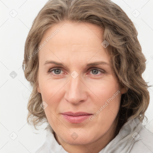 Joyful white adult female with medium  brown hair and blue eyes