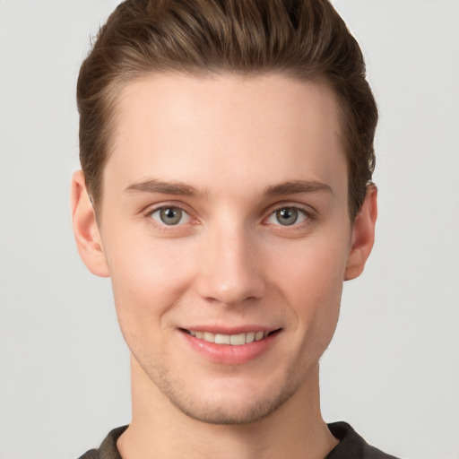 Joyful white young-adult male with short  brown hair and grey eyes