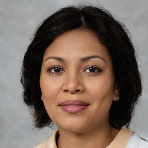 Joyful latino young-adult female with medium  brown hair and brown eyes