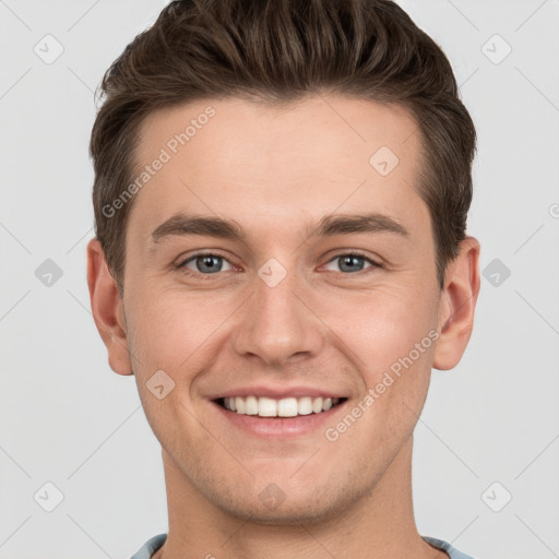 Joyful white young-adult male with short  brown hair and grey eyes