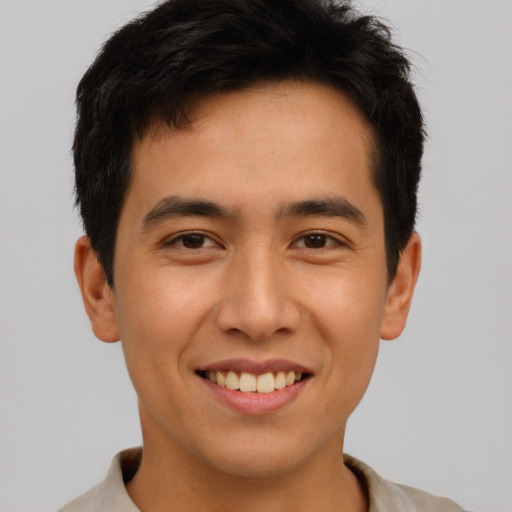 Joyful latino young-adult male with short  brown hair and brown eyes